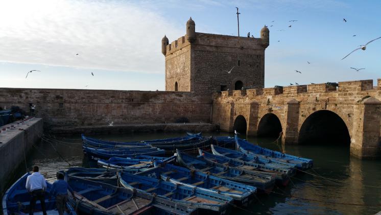 Photo des bateaux dans le port d'Essaouira entouré par la Skara
