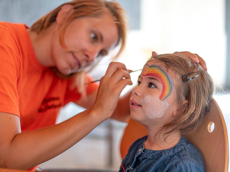 Animateur qui peint le visage d'un enfant 